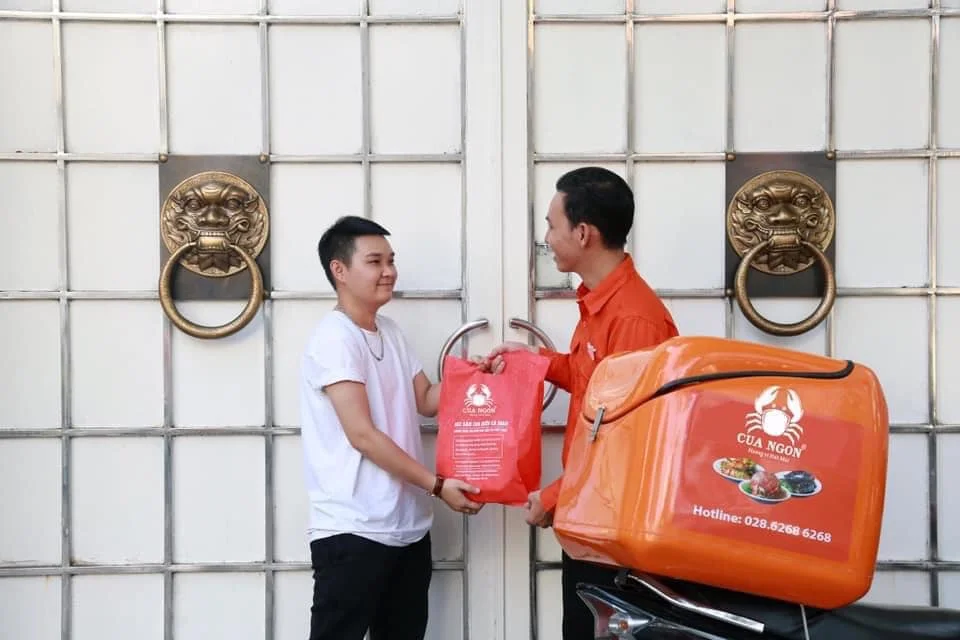 Nhân viên giao hàng Cua Ngon tận tâm giao cua tươi sống đến tận cửa nhà khách hàng
